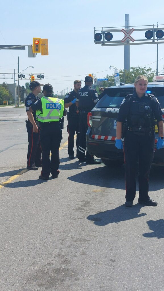 A swarm of police by a police car, making arrests