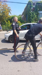 A police officer walking up to the group.